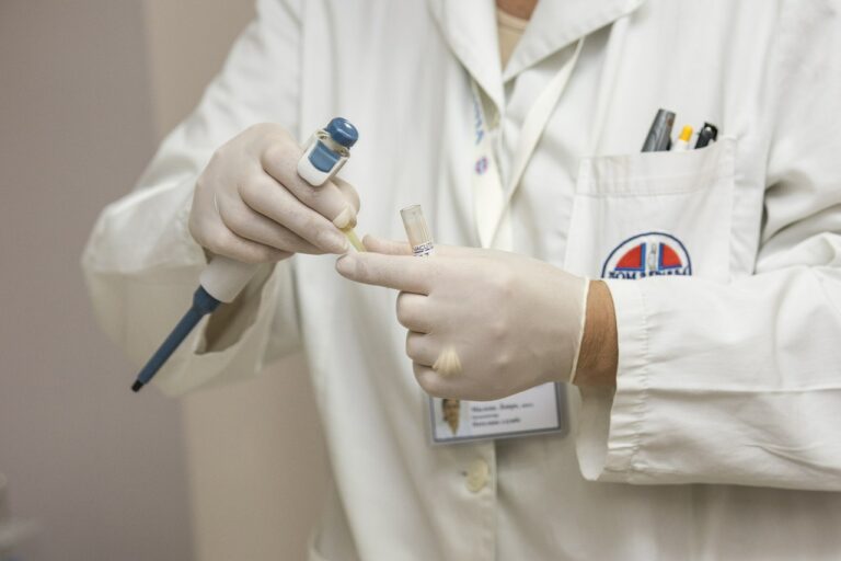 Lab technician handling a sample with gloved hands