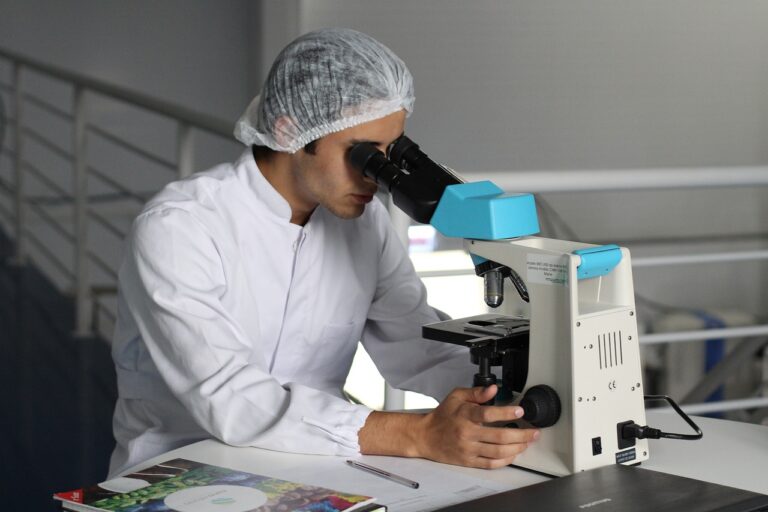 Scientist looking through a microscope in a lab